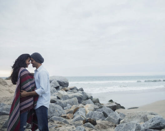 Un jeune couple face à face au bord de la mer